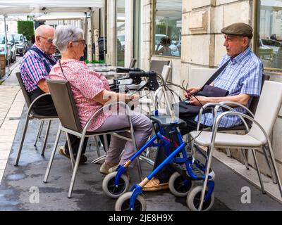 Tre persone anziane che siedono sulla terrazza del bar in attesa di servizio - Tours, Francia. Foto Stock