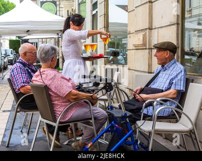 Tre anziani seduti sulla terrazza del bar vengono serviti con bevande - Tours, Francia. Foto Stock