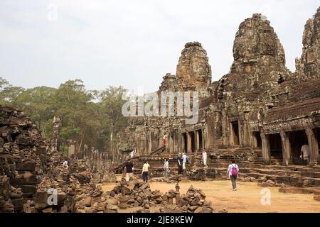 I turisti visitano il tempio di Bayon dove ci sono le facce sorridenti sulla torre facciale, Angkor, Siem Reap, Cambogia. Ogni torre supporta da uno Foto Stock