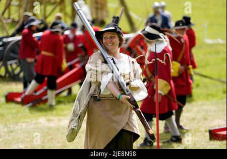 Un membro della milizia di Wimborne porta con sé una pistola a rampart durante il festival di storia della Chalke Valley a Broad Chalke, vicino Salisbury, Wiltshire. Data foto: Domenica 26 giugno 2022. Foto Stock