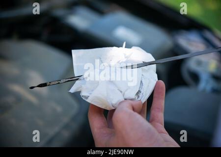 Mani dei tecnici controllo olio motore auto , fuoco selettivo Foto Stock