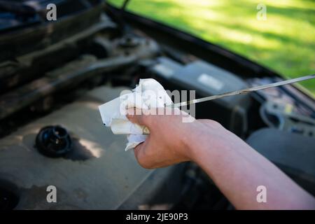 Mani dei tecnici controllo olio motore auto , fuoco selettivo Foto Stock