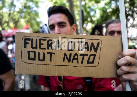 Madrid, Spagna. 26th giugno 2022. Un uomo tiene un cartello contro la NATO durante una manifestazione, mentre migliaia di persone hanno marciato attraverso il centro di Madrid per protestare. La Spagna ospiterà un vertice della NATO a Madrid il 29 e 30th giugno 2022. Credit: Marcos del Maio/Alamy Live News Foto Stock