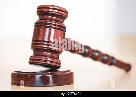 Giudica il gavel di legno poggiato su un plinto di legno su un tavolo in corte Foto Stock