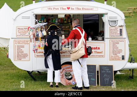 I re-enattori dell'epoca napoleonica acquistano del cibo durante il festival di storia della Chalke Valley a Broad Chalke, vicino Salisbury, Wiltshire. Data foto: Domenica 26 giugno 2022. Foto Stock