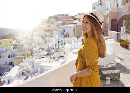 Tramonto a Santorini. Romantica giovane donna attraente godendo il paesaggio del villaggio di Oia a Santorini, Grecia. Foto Stock