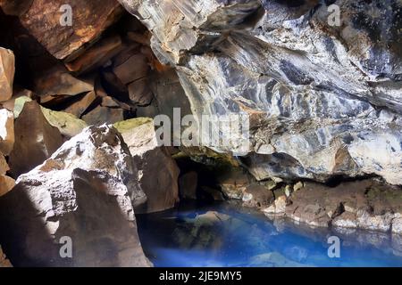 Ammira la grotta di lava di Grjotagja con acque cristalline e blu Foto Stock