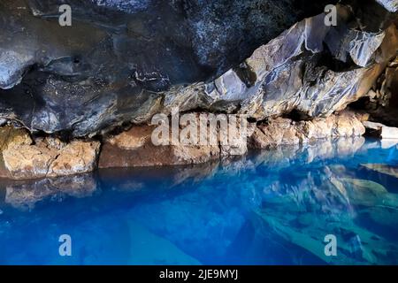 Ammira la grotta di lava di Grjotagja con acque cristalline e blu Foto Stock