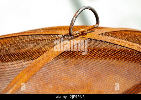 Primo piano di una griglia arrugginita con mesh pesante all'aperto Foto Stock