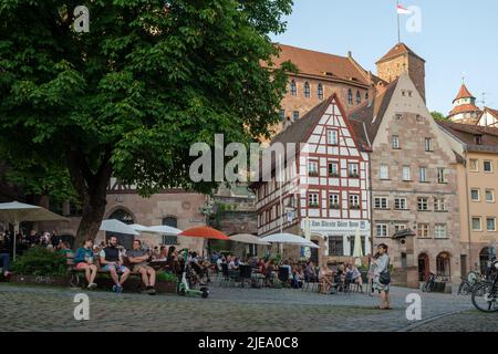 Vista di varie persone seduti all'aperto e bere birra vicino alla casa Albrecht Dürer nella città tedesca di Norimberga. Foto Stock