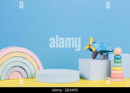 Sfondo del giocattolo del bambino. Giocattoli educativi e forme geometriche podio, piattaforma su sfondo blu e giallo. Vista frontale Foto Stock