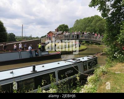 Le folle si riuniscono sul ponte per assistere alla sfilata delle storiche navi a crociera che lavorano lungo il Canal Grande Union all'incrocio di Braunston Turn. Foto Stock