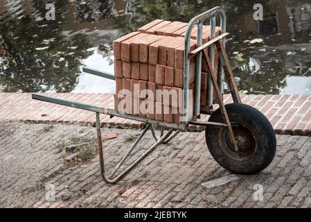 Muratore con carriola Foto stock - Alamy