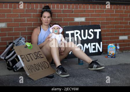 Toledo, Stati Uniti. 25th giugno 2022. Rachel Humberger, 30 anni, di Toledo detiene la sua figlia di 9 mesi Evelyn, e guarda altri bambini giocare durante una protesta contro un cerchio di preghiera anti-aborto. Humberger ha detto: "Sono molto appassionato di uguaglianza e non violare i diritti degli altri. Voglio che il mio bambino cresca in un luogo in cui non deve lottare per il proprio corpo". I manifestanti sono venuti per interrompere un raduno di preghiera che prega di porre fine all'aborto a Toledo, Ohio, sabato 25 giugno 2022. (Foto di Stephen Zenner/SOPA Images/Sipa USA) Credit: Sipa USA/Alamy Live News Foto Stock