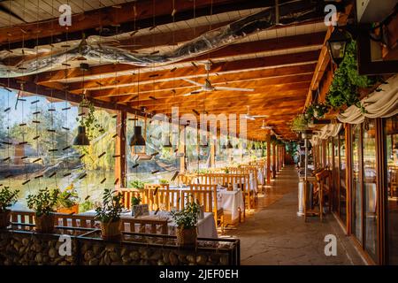 L'interno accogliente del ristorante. Nelle vicinanze troverete mobili in legno e un lago. Foto Stock