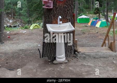 Lavandino esterno con tronco d'albero per lavarsi la mano nei boschi di Kumrat, Pakistan Foto Stock