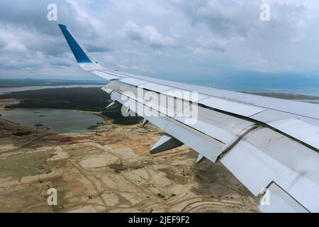 Vista del sedile della finestra dall'ala dell'aereo che volava sopra Singapore Land Foto Stock