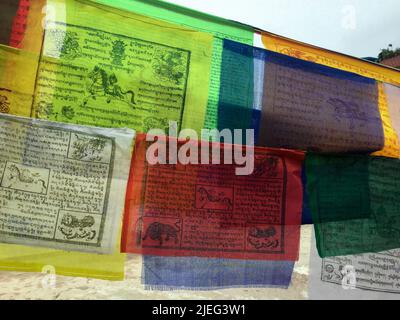 Bandiere di preghiera nepalesi, inscritte con simboli propiziosi, invocazioni, preghiere e mantra, messe in luoghi di pratica spirituale in Himalaya. Foto Stock