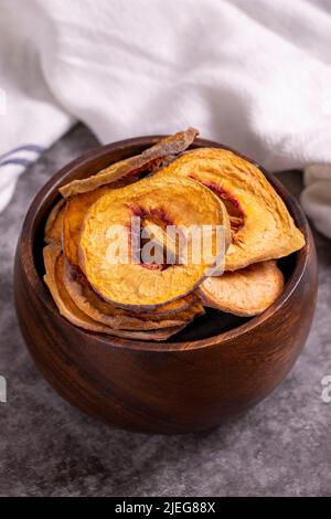 Fette di pesca essiccate. Pesche secche affettato su sfondo scuro. Frutta secca al sole. Primo piano. Foto Stock