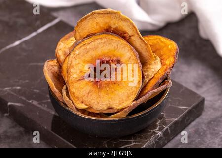 Fette di pesca essiccate. Pesche secche affettato su sfondo scuro. Frutta secca al sole. Primo piano. Foto Stock