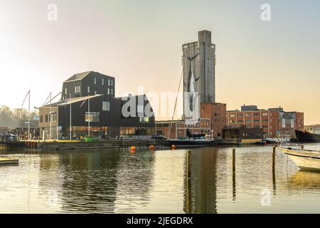 I turisti e gli abitanti di Odense passeggiano lungo la banchina in una giornata di sole primaverili al porto commerciale di Odense. Odense, Fyn, Danimarca, Europa Foto Stock