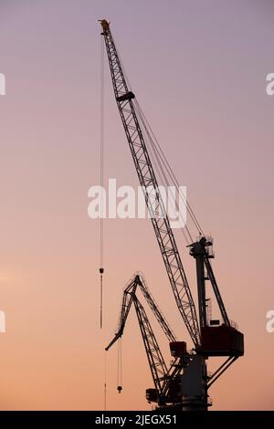 Helsinki / Finlandia - 26 GIUGNO 2022: Una silhouette di una vecchia gru da cantiere contro il tramonto Foto Stock