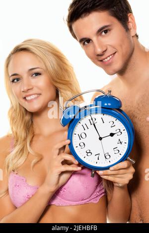 Zeitumstellung, Uhrenumstellung, Sommerzeit, Winterzeit, Paar mit Wecker, 25, 30, Jahre, Foto Stock