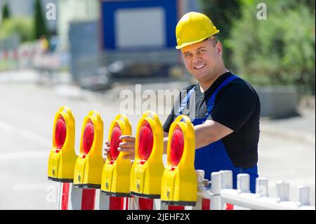 Arbeiter überprüft die Baustellenabsperrung , Mann, 35, 40, Jahre, Gelber Schutzhelm, Foto Stock