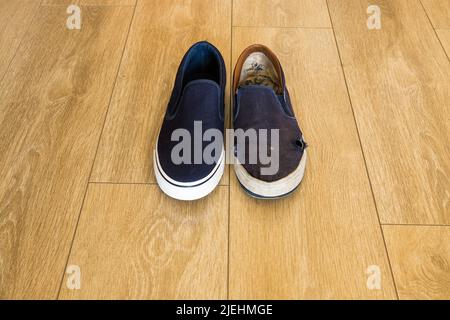 Confronto netto - scarpe blu e bianche - nuove contro vecchie e usurate - disuguaglianza Foto Stock