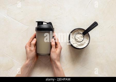 Flacone per agitatore sportivo in mani e proteine del siero di latte in vaso. Fitness e dieta palestra nutrizione Foto Stock
