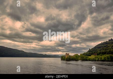 Le rovine della fortezza medievale del 16th secolo Castello di Urquhart sulle rive di Loch Ness nella Grande Glen nelle Highlands della Scozia, nuvole pesanti Foto Stock