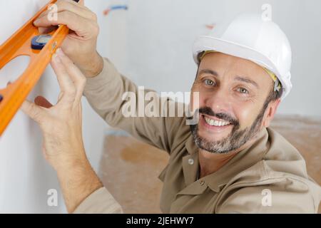 un commerciante che usa il livello di spirito Foto Stock