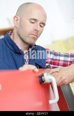Immagine ritagliata di fissaggio lockpicker maniglia della porta a casa Foto Stock