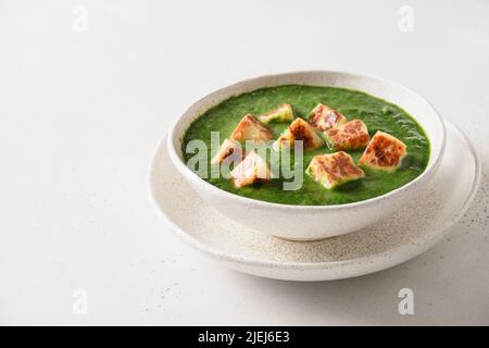 Paneer Palak servito con chapati e riso basmati isolato su sfondo bianco. Cucina vegetariana indiana a base di spinaci e formaggio paneer. Foto Stock