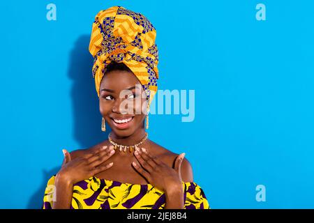 Ritratto di pelle piuttosto allegra ragazza braccia sul petto guardare spazio vuoto Toothy sorriso isolato su sfondo di colore blu Foto Stock