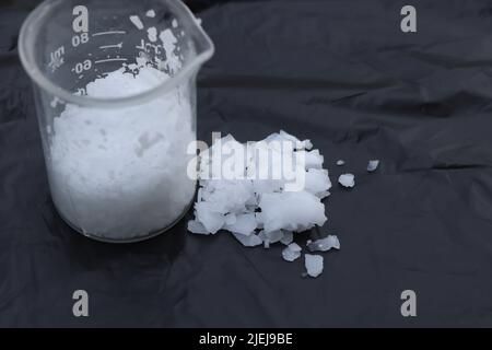 scaglie di soda caustica, scaglie di idrossido di sodio sostanza chimica pericolosa Foto Stock