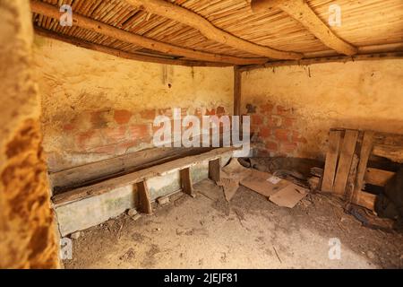 Interno di fienile con legno sporco e panca rotta Foto Stock