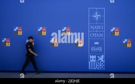 Madrid, Spagna. 27th giugno 2022. Un poliziotto passa accanto alla segnaletica nel luogo del prossimo vertice NATO a Madrid, in Spagna, il 27 giugno 2022. La Spagna ospiterà un vertice della NATO di due giorni a partire da giugno 29. Foto di Paul Hanna/UPI Credit: UPI/Alamy Live News Foto Stock