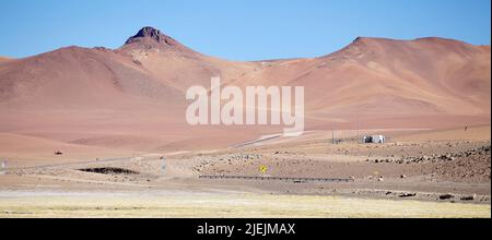 La strada percorre il deserto di Atacama, Cile. Il deserto di Atacama è un altopiano in Sud America, striscia di terra della costa del Pacifico, ad ovest delle Andes mountai Foto Stock