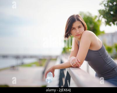 asian giovane forte, donna fiduciosa in abiti sportivi sensazione di male in procinto di buttare in su. Disidratazione. Dolore toracico. Cucitura laterale, crampi laterali dopo il funzionamento. Mal di stomaco dopo il jogging. Foto Stock