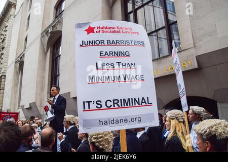 Londra, Regno Unito. 27th giugno 2022. Un barrister tiene un cartello che afferma che i barrister junior guadagnano meno del salario minimo, durante il rally. I barristi criminali si sono riuniti al di fuori del Tribunale penale centrale, noto come Old Bailey, mentre iniziano il loro sciopero sulle tasse di pagamento e di aiuto legale. (Foto di Vuk Valcic/SOPA Images/Sipa USA) Credit: Sipa USA/Alamy Live News Foto Stock