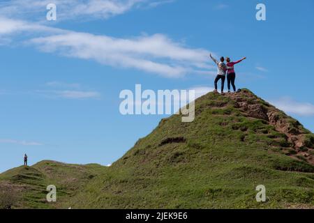 I turisti a Fairy Glen sulla Penisola di Trotternish. Paesaggio variegato con colline, valli e scogliere di basalto a nord di Skye. La zona soffre di turismo eccessivo. Foto Stock