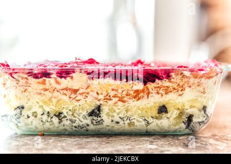 Primo piano di strati di verdure tradizionale insalata russa chiamato sseledka pod shuba aringa sotto cappotto di pelliccia fatto con barbabietole stratificate di patate, Foto Stock