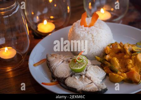 Tradizionale pesce alla griglia con contorno di lime e riso con verdure. Foto: Garyroberts/worldwidefeatures.com Foto Stock