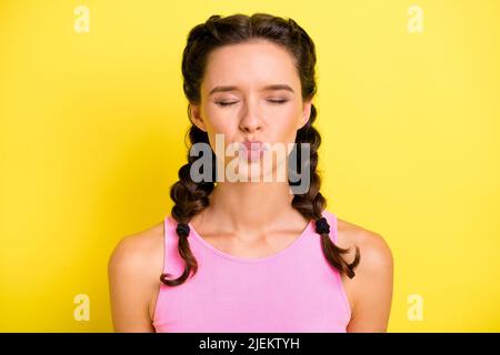 Foto di graziose trecce ragazza vestita singlet invio bacio occhi chiusi isolato colore giallo sfondo Foto Stock