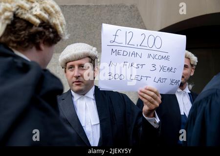 Londra, Regno Unito. 27th giugno 2022. Un barrister criminale junior tiene segno fuori del Bailey vecchio. I barristi criminali scoppano dai tribunali in sciopero intorno al Regno Unito per disputa in pay. La Criminal Bar Association (CBA) ha dichiarato che i redditi per i barristi criminali junior sono scesi del 30% negli ultimi 20 anni e che hanno raggiunto un reddito medio dopo le spese di £12200 nei primi 3 anni di pratica. Essi richiedono un aumento del 25% della tassa di assistenza legale, che è superiore al 15% minimo raccomandato dalla revisione penale di assistenza legale pubblicata lo scorso dicembre. Credit: SOPA Images Limited/Alamy Live News Foto Stock
