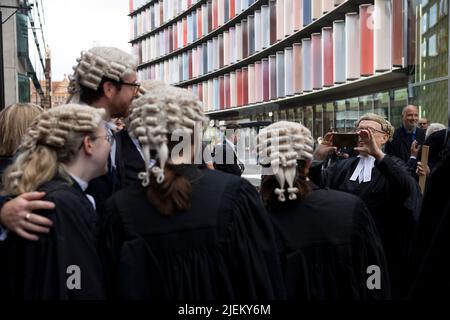 Londra, Regno Unito. 27th giugno 2022. Un barrister criminale scatta una foto dei suoi colleghi minori a Old Bailey. I barristi criminali scoppano dai tribunali in sciopero intorno al Regno Unito per disputa in pay. La Criminal Bar Association (CBA) ha dichiarato che i redditi per i barristi criminali junior sono scesi del 30% negli ultimi 20 anni e che hanno raggiunto un reddito medio dopo le spese di £12200 nei primi 3 anni di pratica. Essi richiedono un aumento del 25% della tassa di assistenza legale, che è superiore al 15% minimo raccomandato dalla revisione penale di assistenza legale pubblicata lo scorso dicembre. Credit: SOPA Images Limited/Alamy Live News Foto Stock