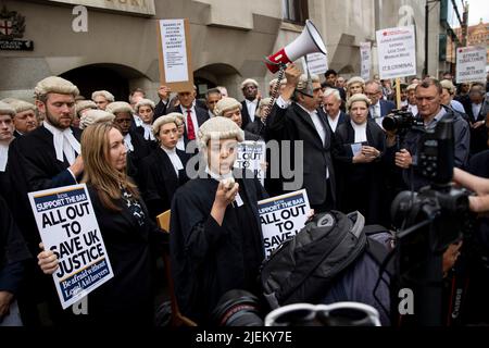 Un barrister junior sta dando un discorso al di fuori di Old Bailey durante l'azione di sciopero a Londra. I barristi criminali scoppano dai tribunali in sciopero intorno al Regno Unito per disputa in pay. La Criminal Bar Association (CBA) ha dichiarato che i redditi per i barristi criminali junior sono scesi del 30% negli ultimi 20 anni e che hanno raggiunto un reddito medio dopo le spese di £12200 nei primi 3 anni di pratica. Essi richiedono un aumento del 25% della tassa di assistenza legale, che è superiore al 15% minimo raccomandato dalla revisione penale di assistenza legale pubblicata lo scorso dicembre. Foto Stock