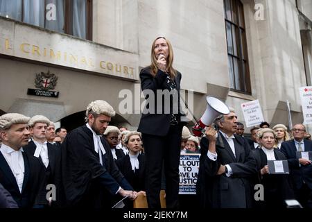 Kelly Hutchinson, un barrister criminale junior, è visto dare un discorso fuori da Old Bailey durante l'azione di sciopero a Londra. I barristi criminali scoppano dai tribunali in sciopero intorno al Regno Unito per disputa in pay. La Criminal Bar Association (CBA) ha dichiarato che i redditi per i barristi criminali junior sono scesi del 30% negli ultimi 20 anni e che hanno raggiunto un reddito medio dopo le spese di £12200 nei primi 3 anni di pratica. Essi richiedono un aumento del 25% della tassa di assistenza legale, che è superiore al 15% minimo raccomandato dalla revisione penale di assistenza legale pubblicata lo scorso dicembre. Foto Stock