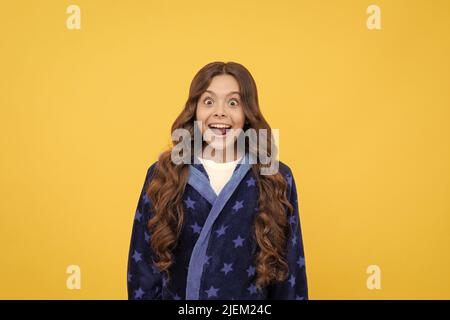 felice sorprendo ragazza capretto in sleepwear dopo risveglio di mattina, felicità Foto Stock